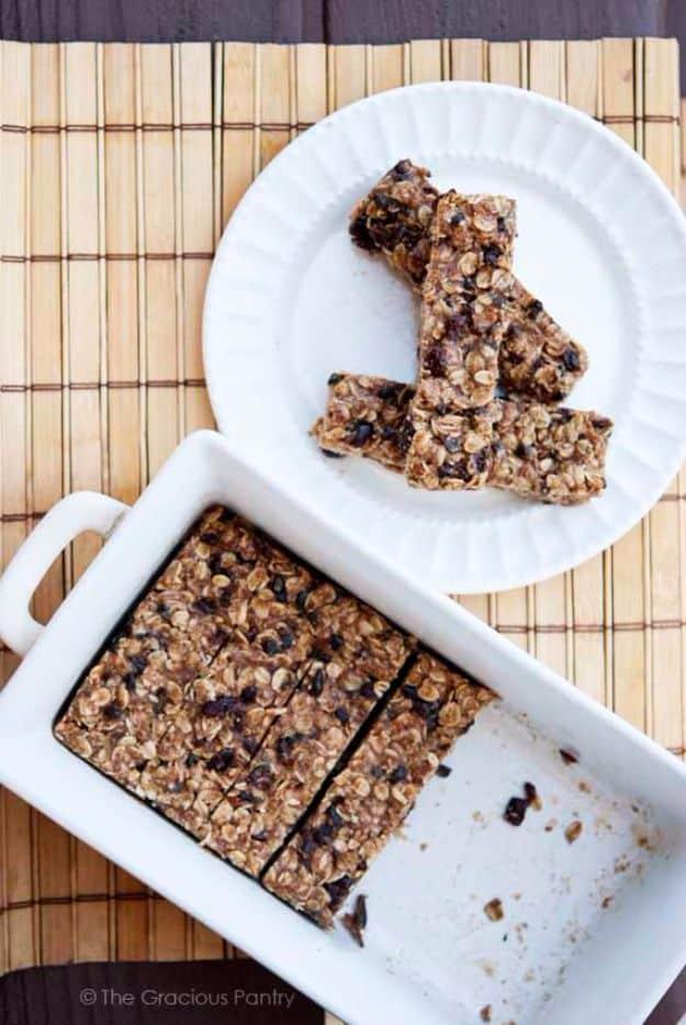No bake oatmeal granola bars cut into bars on a white plate beside a white baking dish on a bamboo mat