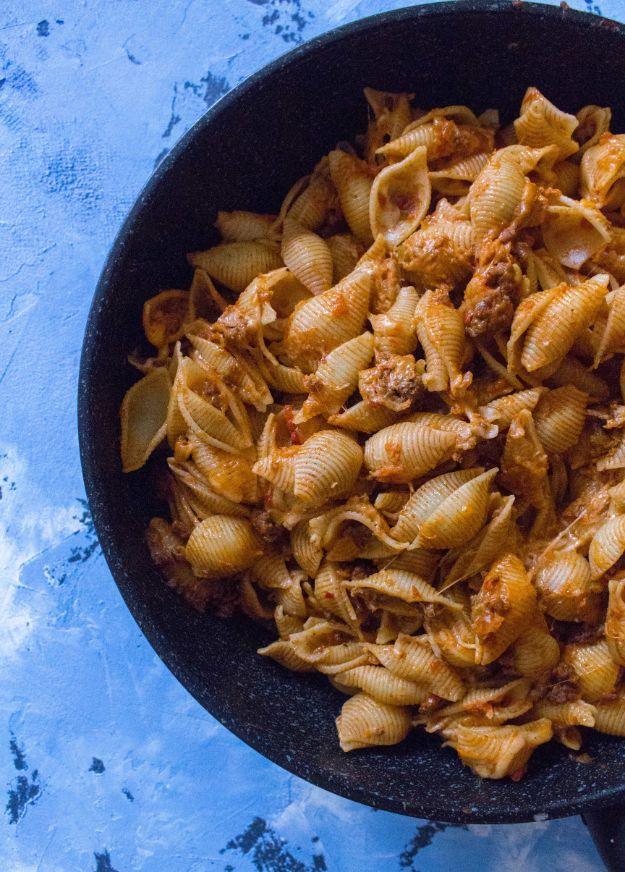 Last minute taco pasta with small shells coated in seasoned ground beef and melted cheese in a black skillet