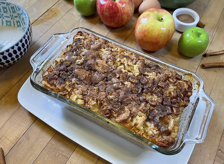Apple Desserts - whole baked apple loaf with a browned cinnamon streusel top, still unglazed, in a glass dish on a white platter