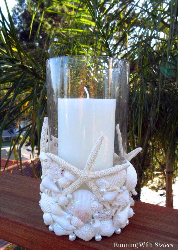 Beachcomber seashell candleholder, a glass cylinder covered in white shells and starfish with a pillar candle