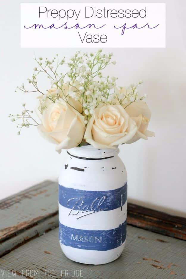 A chalk painted mason jar vase sanded back to bare glass at the edges, a country craft idea holding dried stems
