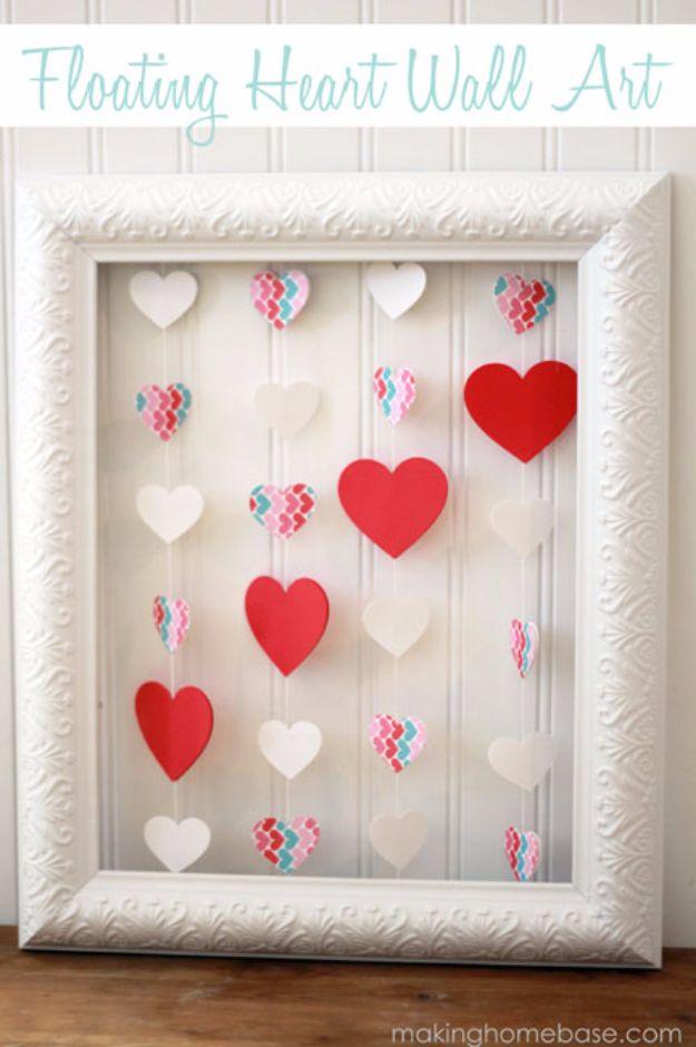 An empty white picture frame strung with twine and paper hearts as floating Valentine's Day wall art