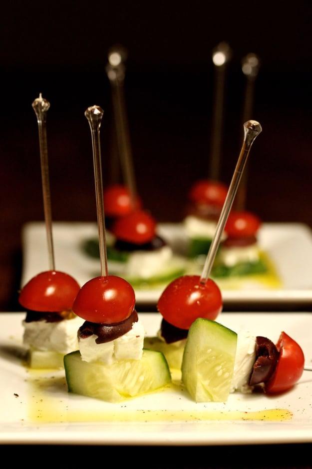 Greek salad skewers with cucumber, cherry tomato, kalamata olive and cubed feta stacked on wooden picks
