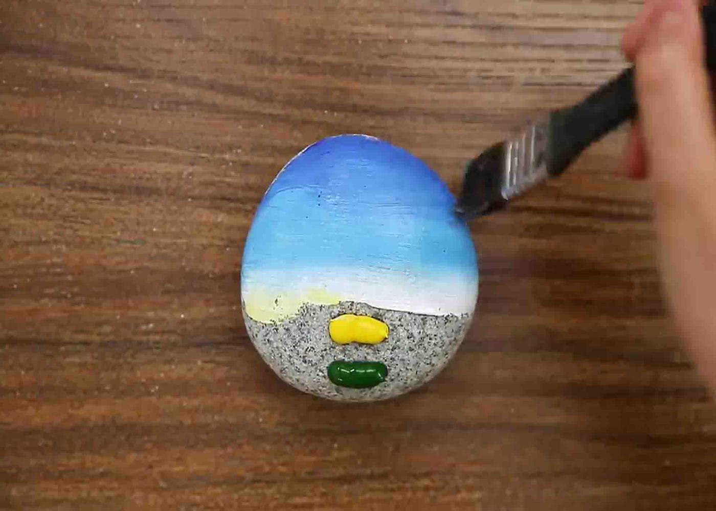 Spreading the acrylic paint across the stone