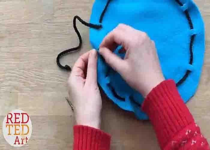 Threading the string to the fabric to make the mini pouch