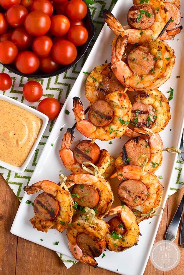 Spicy shrimp and sausage skewers off the grill, jumbo shrimp curled around slices of andouille on a cookout table