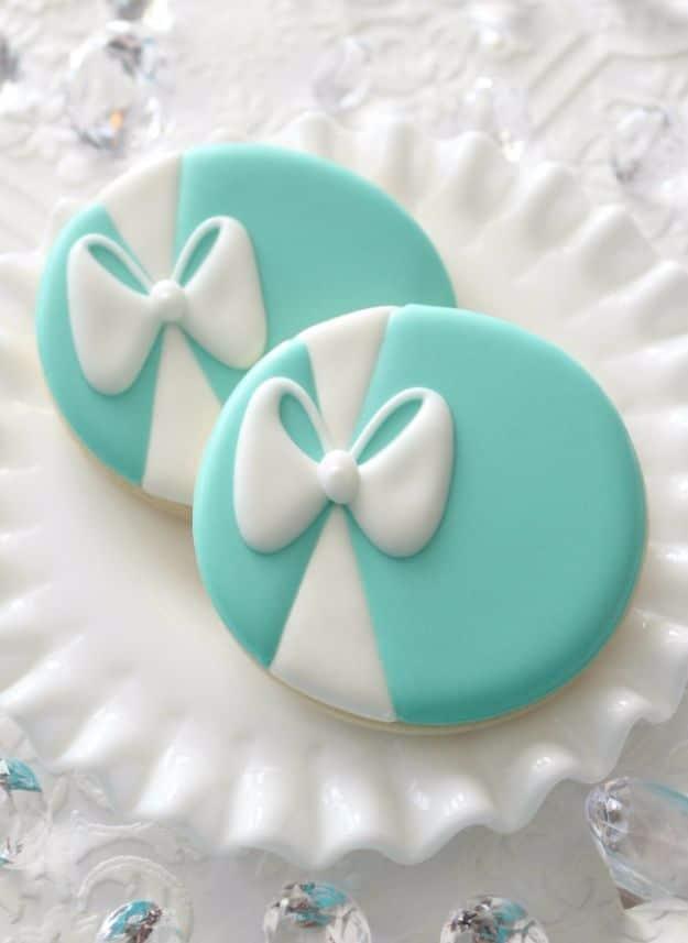 Tiffany blue sugar cookies iced in a soft robins egg shade, each one finished with a white piped ribbon and bow