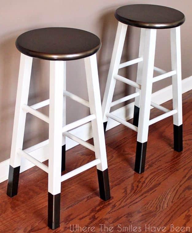 Bronze dipped bar stools painted white with metallic bronze round seats and bronze dipped feet on a wood floor