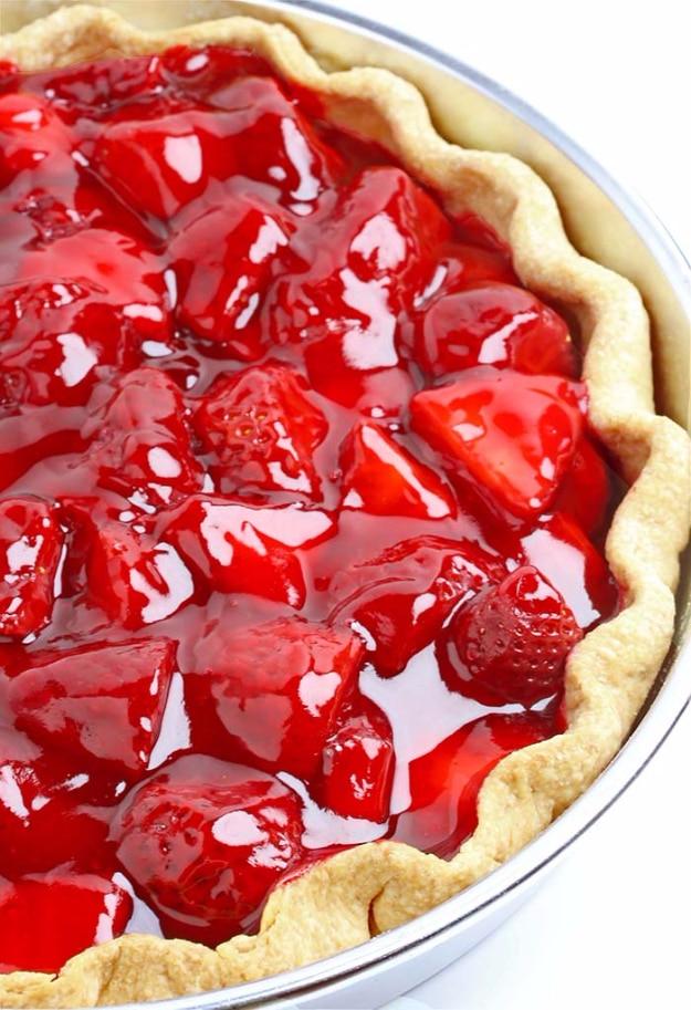 Fresh strawberry pie packed with glossy quartered strawberries in a glaze inside an all butter crust
