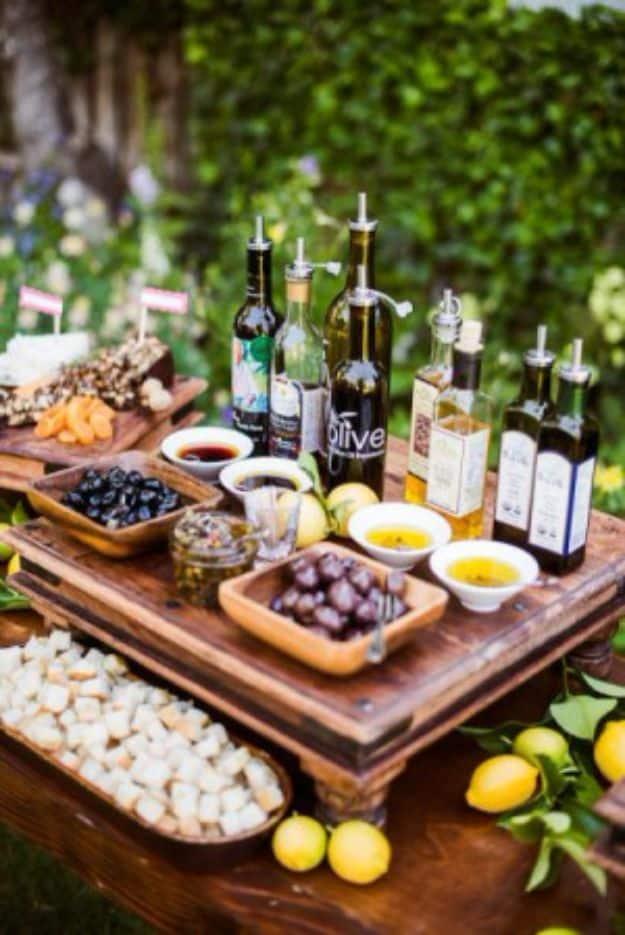 Bread dipping bar with olive oil and vinegar bottles, small bowls of spices and olives, lemons and sliced bread
