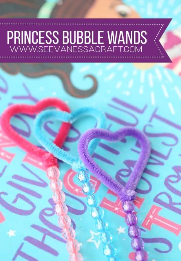 Pink and purple pipe cleaner bubble wands bent into heart shapes with beaded handles on a bright card