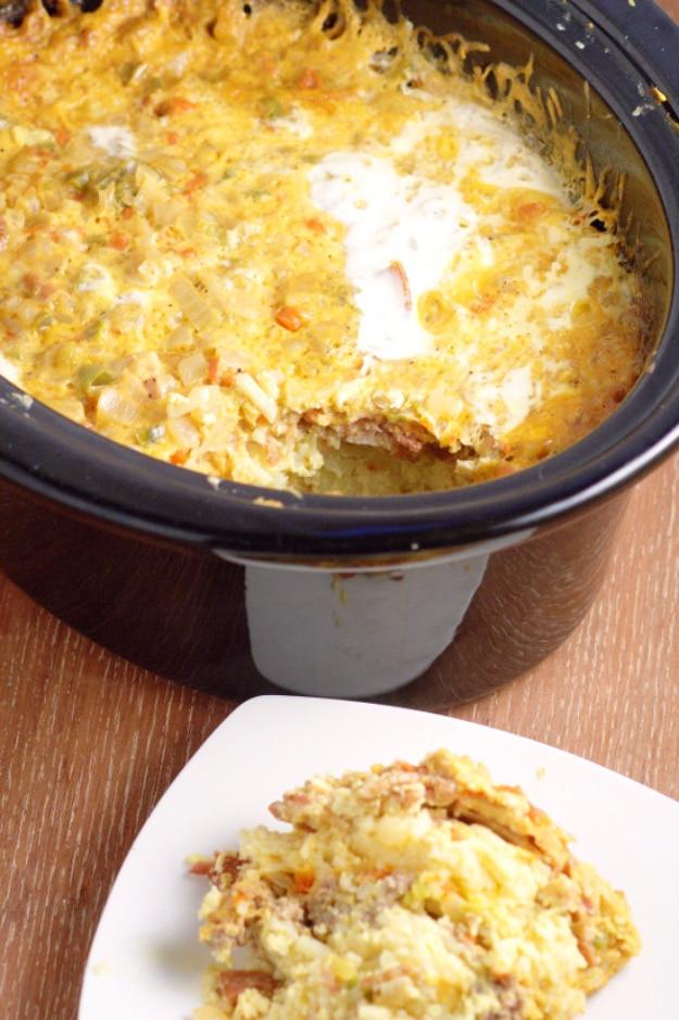 Crock pot breakfast casserole with eggs, cheese and hash browns in a slow cooker with a plated serving