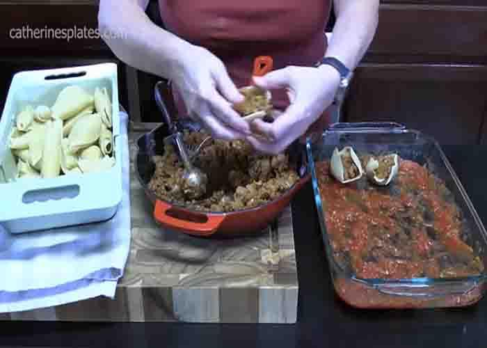 Layering the taco-stuffed pasta shells on the casserole dish
