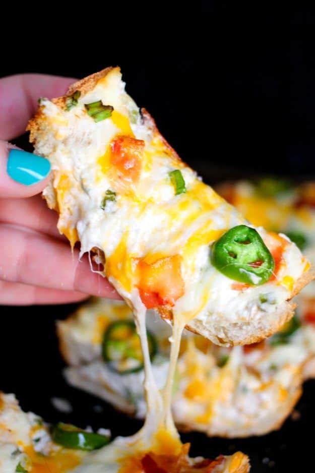 Jalapeno popper cheese bread pulled apart showing stretchy melted cheese with jalapeno rounds on top