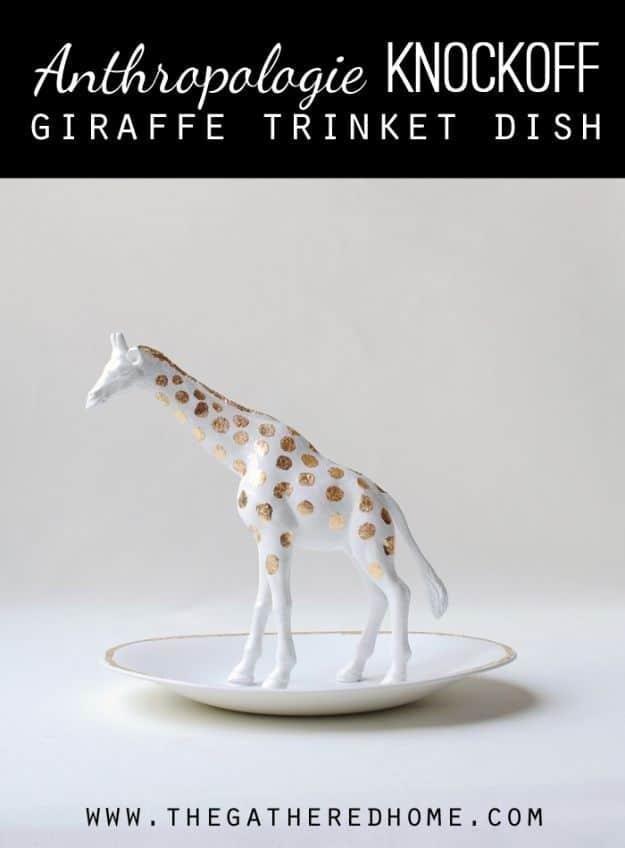 White ceramic oval trinket dish with a gold spotted toy giraffe standing in the center on a dark background