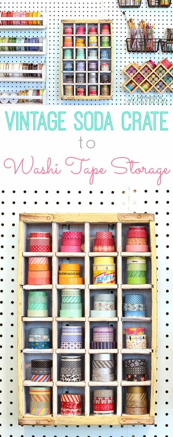 Vintage wooden soda crate mounted on white pegboard, its divided compartments stacked with washi tape rolls by color