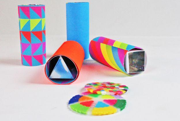Mini DIY kaleidoscope, three paper covered cardboard tube kaleidoscopes beside two translucent beaded discs