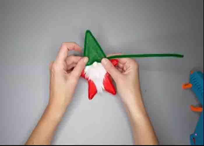 Gluing the pipe cleaner on the star gnome ornament