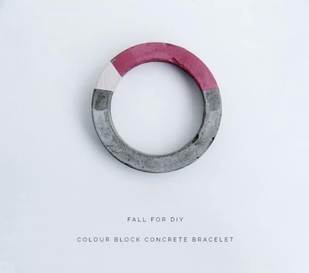 Colour block concrete bracelet, a chunky cast cement bangle painted in thirds of raw gray, white and dusty pink
