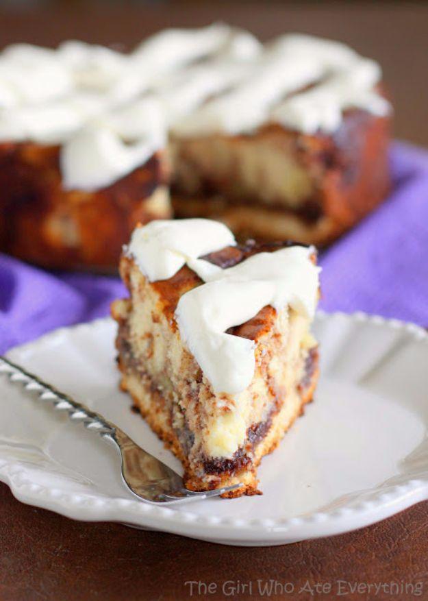 Cinnamon roll cheesecake slice showing a cinnamon swirl through the filling under thick cream cheese frosting