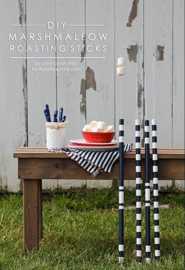 DIY marshmallow roasting sticks graphic, long navy and white striped handles leaning against a garden bench