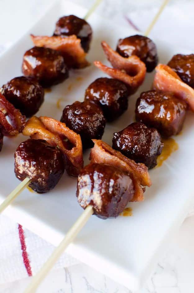 Crock pot bourbon bacon meatballs glazed in barbecue sauce and threaded onto skewers with crisp bacon