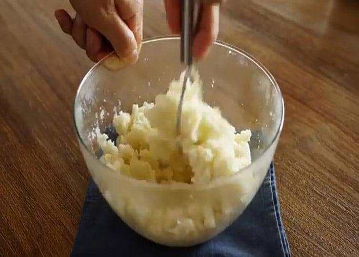 Mashing the potatoes to make garlic potato chips