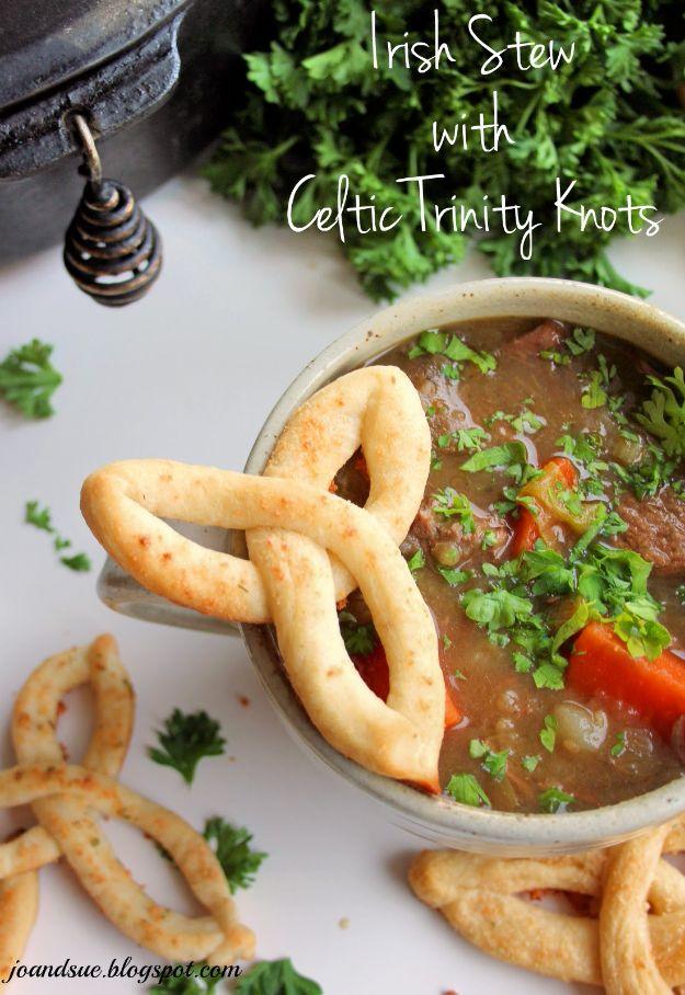Beef and carrot stew in a speckled stoneware bowl with braided Celtic knot breadsticks and fresh parsley