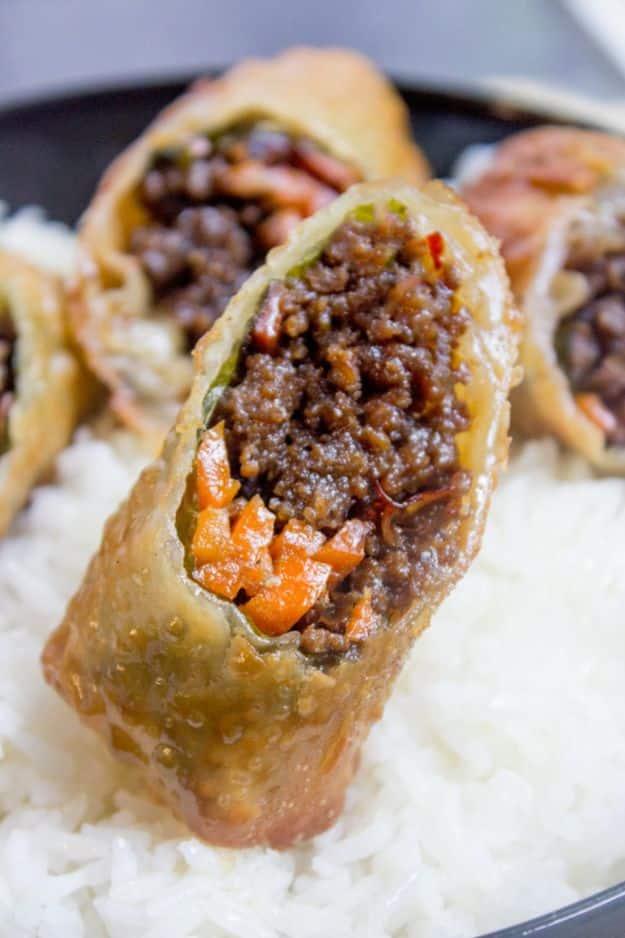 Korean ground beef egg rolls fried golden and stacked on a plate with napa cabbage and carrot filling