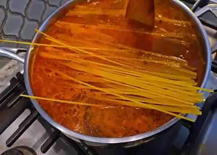 Adding the spaghetti into the meat sauce
