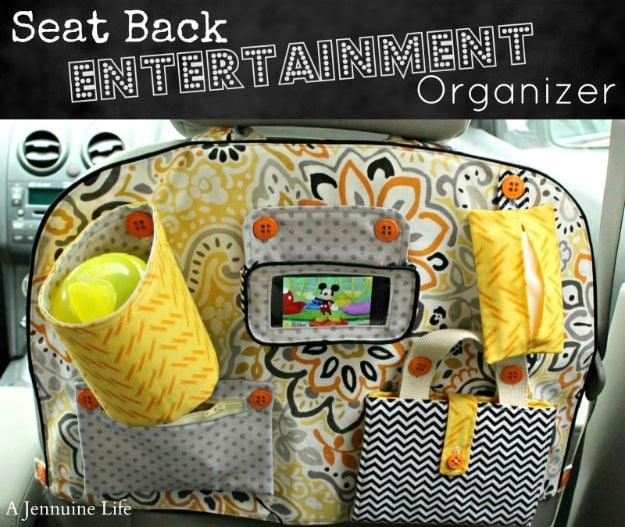 Seat back entertainment organizer, a yellow and gray floral panel with a phone window, cup, tissues and a chevron pouch