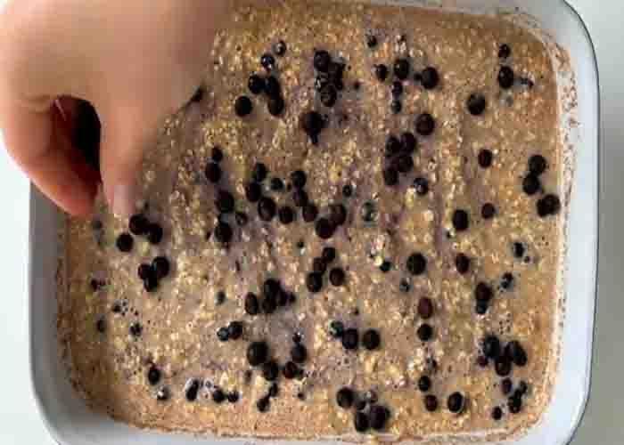 Adding the blueberries top of the baked oats casserole