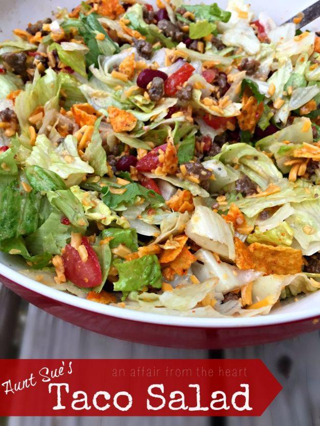 Aunt Sue's Doritos taco salad with iceberg, kidney beans, ground beef and cheddar in a red rimmed bowl