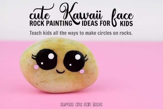 Smooth rock painted with a cute kawaii face, big black eyes and pink cheeks, on a bright pink background