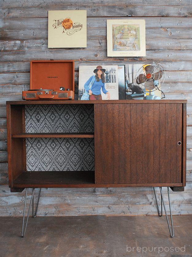Dark walnut stained buffet cabinet on hairpin legs with a sliding door, patterned fabric lined interior and a record player