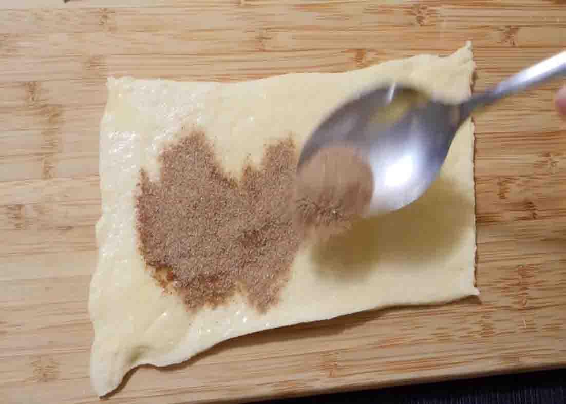 Putting the cinnamon mixture over the pillsbury crescent rolls