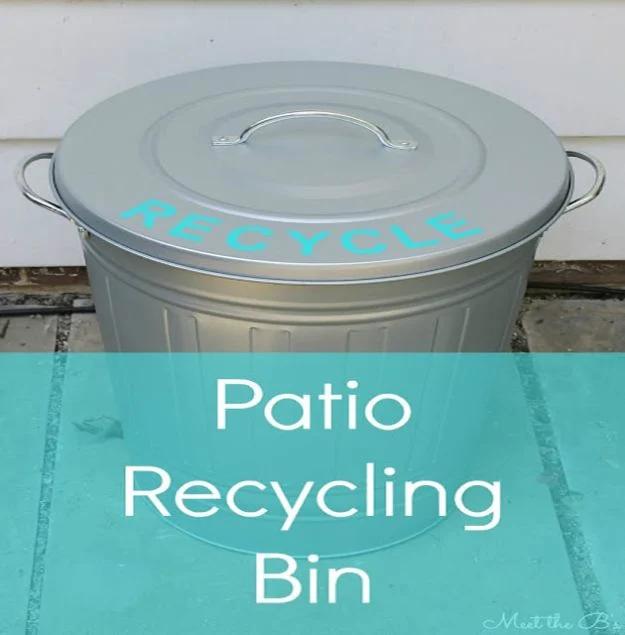 Galvanized metal trash can with a domed lid lettered RECYCLE in teal vinyl, under a wide typeset teal band