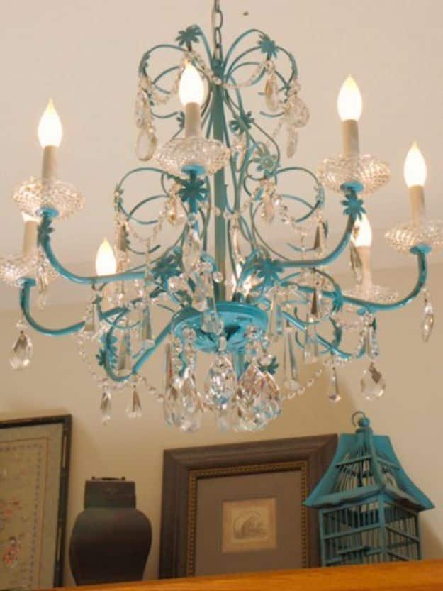 Turquoise chandelier redo in Rustoleum Seaside with clear cut crystals hanging from every arm against a pale wall
