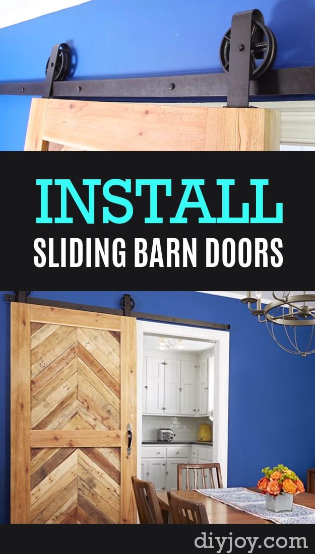 DIY home repair: a herringbone pallet wood barn door on black track hardware against a bright blue dining room wall