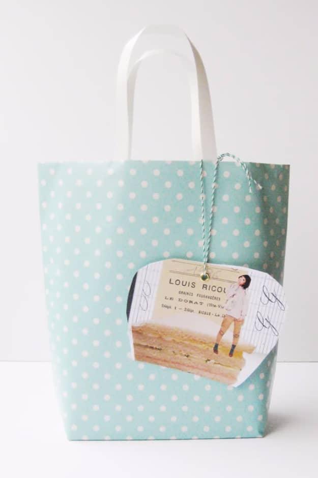 Paper gift bag folded from mint polka dot wrapping paper with white handles and a small gift tag attached