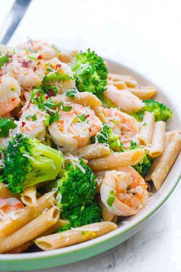 Shrimp and broccoli penne in a shallow bowl, penne with pink shrimp and bright green broccoli florets