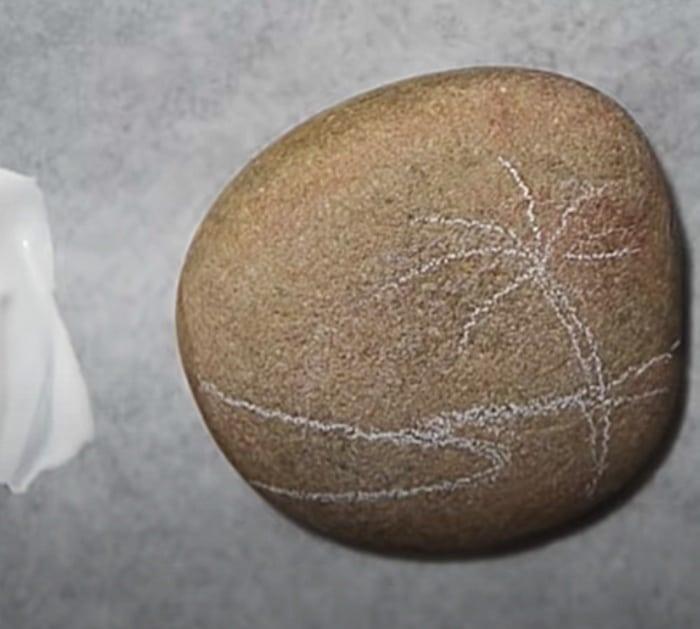 Paint a small rock with gesso and make a beach scene