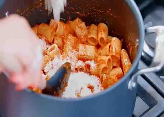 Tossing the pasta and the red pepper sauce