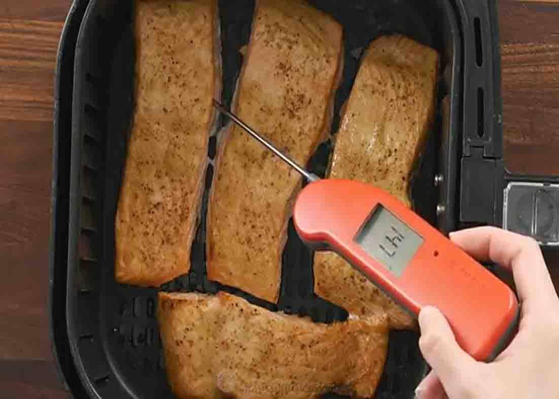 Checking the temperature of the salmon filet with a thermometer