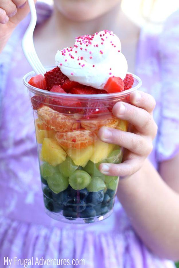 Rainbow fruit cups layered with strawberries, pineapple and grapes in clear cups for a party, a no cook kids party snack