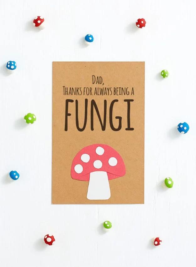 Kraft Father's Day card with a cut paper red toadstool reading thanks for being a fungi, among toy mushrooms