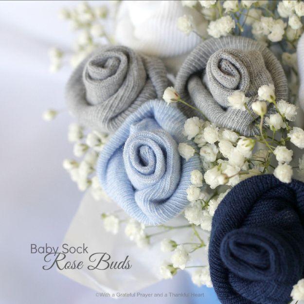 DIY baby shower decoration with grey blue and navy baby socks rolled into rosebuds among white gypsophila sprigs