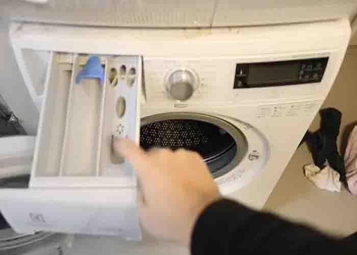 Loading the washing machine with bleach and vinegar