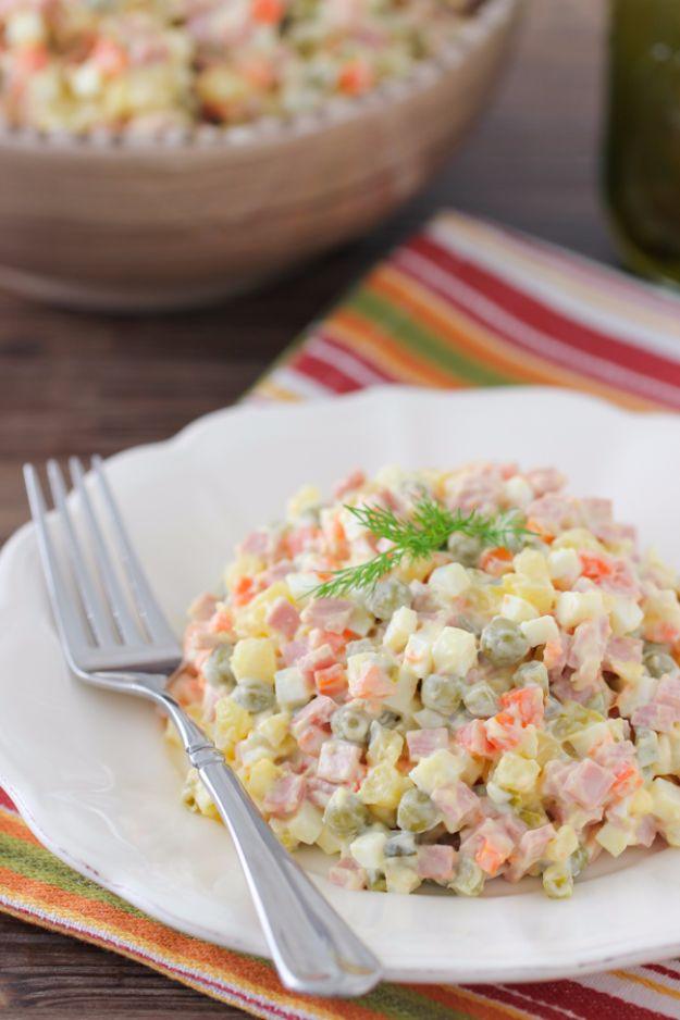 Russian Olivier salad mounded on a white plate with diced potato, carrot, peas and pickles in mayonnaise
