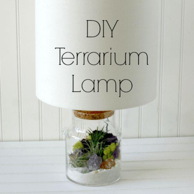 DIY terrarium lamp, a glass jar of moss and air plants under a white lamp shade mounted on the jar lid on a white shelf
